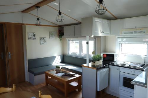 a small kitchen with white cabinets and a table at AquaHause in Pataias