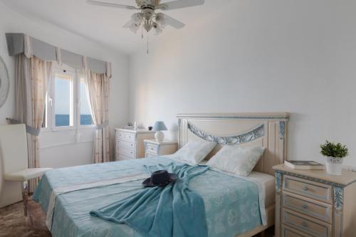 a bedroom with a bed with a blue blanket on it at 1 Line Beachfront Apartment with stunning sea view in Sitio de Calahonda