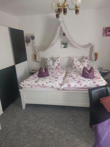 a bed with pink and white sheets and pillows at Pension Jagdhütte in Sankt Andreasberg
