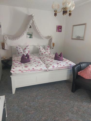 a white bed with pillows on it in a room at Pension Jagdhütte in Sankt Andreasberg