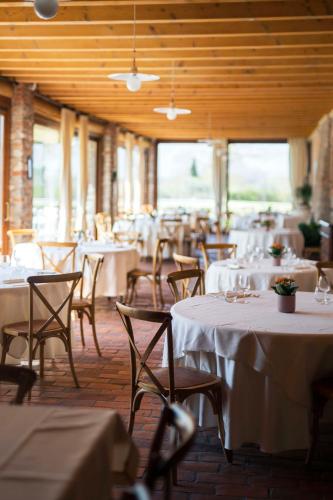 a restaurant with tables and chairs with white table cloth at Fenil Conter Cottage & Suite in Pozzolengo