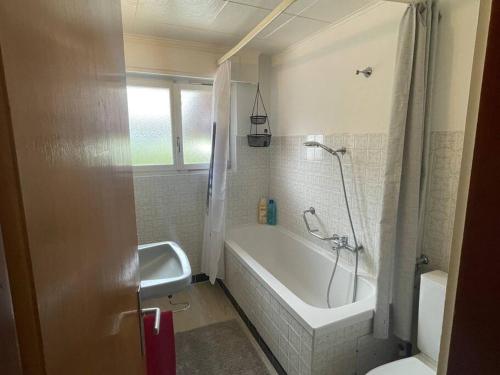a bathroom with a tub and a toilet and a sink at Spacieux, situation idéale pour visiter le Valais in Veyras