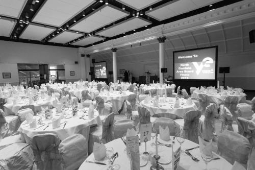 a large banquet hall with tables and chairs and a screen at Crown & Mitre Hotel in Carlisle