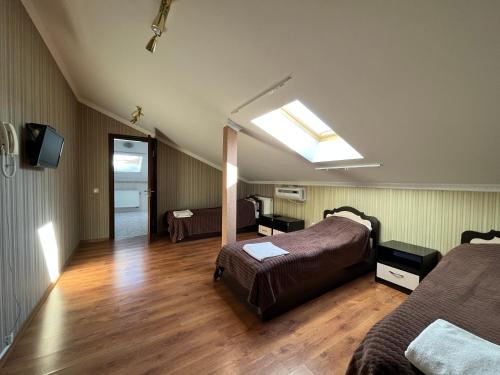 una camera d'albergo con due letti e un lucernario di Готель МАГНАТ 