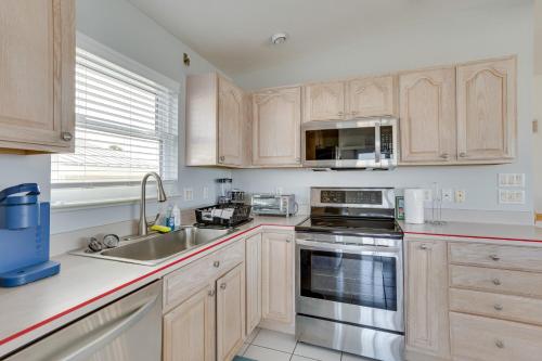 a kitchen with wooden cabinets and stainless steel appliances at Nettles Island, Jensen Beach Home with Patio and Grill in Jensen Beach