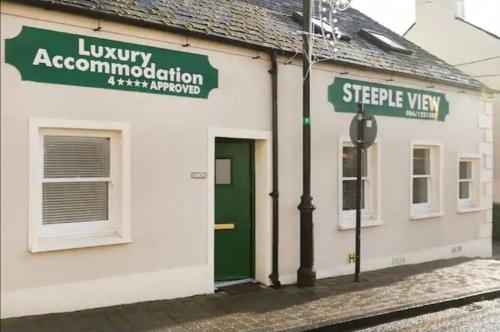 un edificio blanco con una puerta verde y un letrero de la calle en 33A Steepleview, en Trim