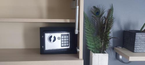 a black and white clock in a room with a potted plant at APARTMAN POZORISTE Penthaus in Banja Luka