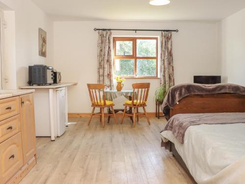 a bedroom with a bed and a table and chairs at Wheatfield Lodge in Fethard on Sea