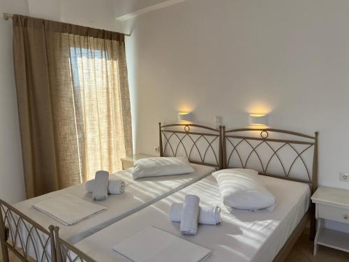 una camera da letto con un grande letto con lenzuola e asciugamani bianchi di Hotel Chrisoula a Città di Antiparo