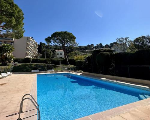 a large blue swimming pool in a yard at Superb luxury Flat garden pool tennis in Le Cannet