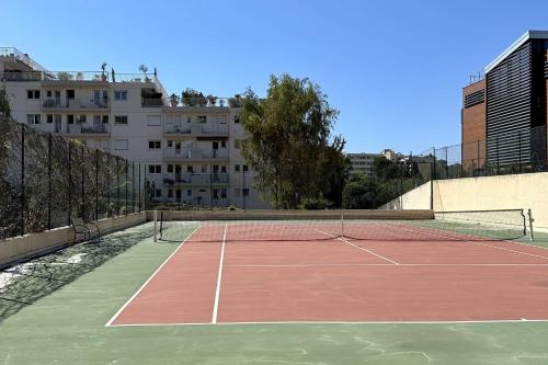 a tennis court with a net in a city at Superb luxury Flat garden pool tennis in Le Cannet