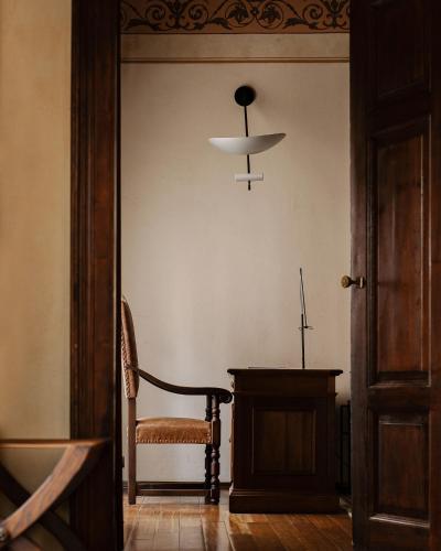 a room with a chair and a table and a chandelier at Hotel Copernicus in Kraków