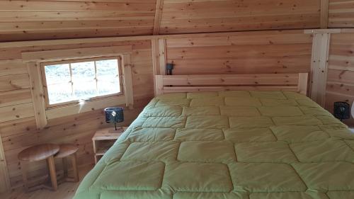 une chambre avec un lit dans une cabane en rondins dans l'établissement Kota SHANTYHOME, à Saint-Martin-dʼArc