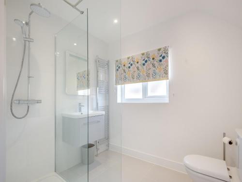 een witte badkamer met een douche en een wastafel bij Garway Cottage in Ross on Wye