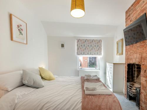 een witte slaapkamer met een bed en een open haard bij Garway Cottage in Ross on Wye