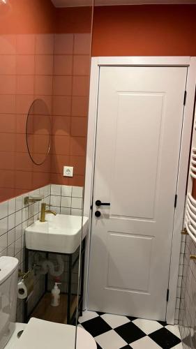 a bathroom with a white door and a sink at Polifonia Inn Borjomi in Borjomi