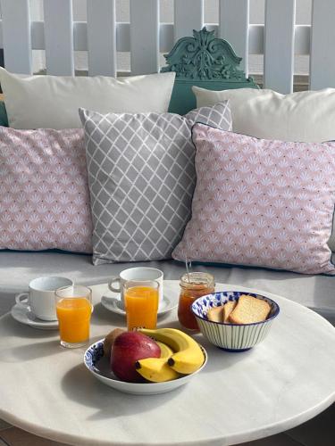 a coffee table with fruit and drinks on a couch at Beachfront House Pythagorion in Pythagoreio