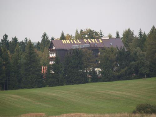 a hotel with a sign on top of a field at Hotel Pavla Vysočina in Nové Město na Moravě