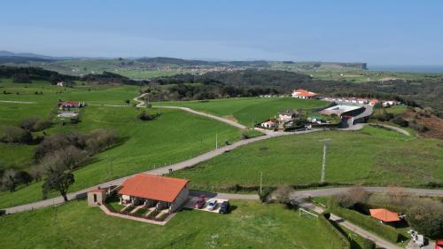 an aerial view of a green field with a house at Villas Verdemar in Isla