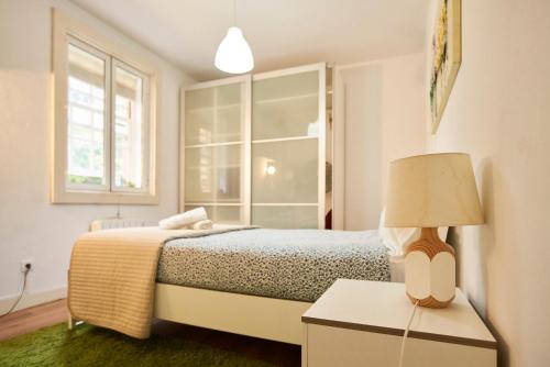 波多的住宿－Riverside (with 3 Bedrooms) by JC，一间卧室配有一张床和一张桌子上的台灯
