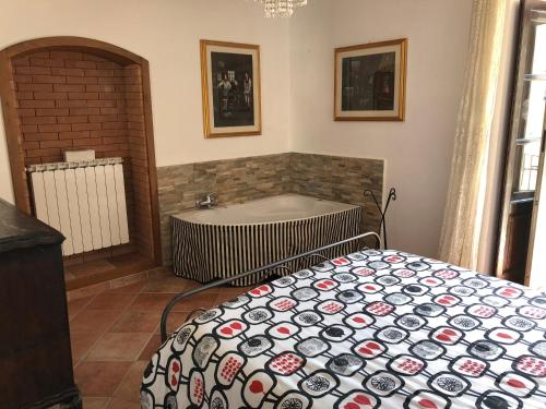 ein Schlafzimmer mit einer Badewanne und einem Bett mit einer Tagesdecke in der Unterkunft Maison Fonticella, HOST APARTMENTS in Rivisondoli