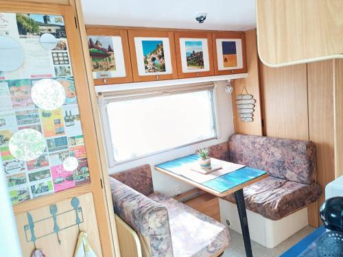 ein kleines Zimmer mit einem Tisch und einem Schreibtisch in einem Wohnwagen in der Unterkunft Caravane Insolite l'Ardéchoise, L'ECHAPPEE BELLE D'AUBENAS Gîtes Appart hôtel Logement 3 sur 3 in Aubenas