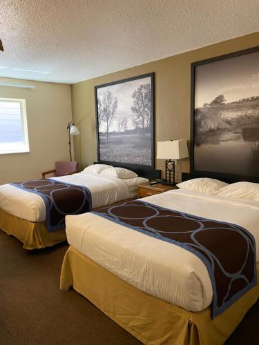 una habitación de hotel con 2 camas y un cuadro en la pared en Super 8 by Wyndham Ogallala en Ogallala