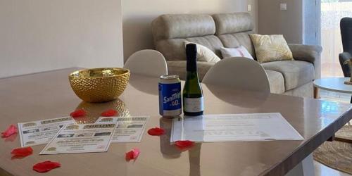 een woonkamer met een tafel met 2 flessen wijn bij Penthouse Casa Baja las Palmeras - Roda Golf in San Javier