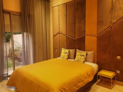 a bedroom with a large yellow bed and a window at vacances luxe in Marrakesh