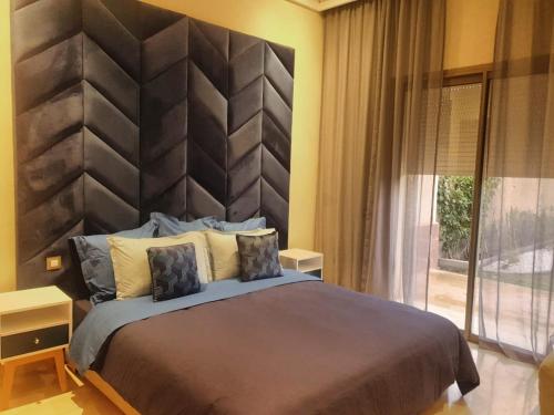 a bedroom with a large bed with a large headboard at vacances luxe in Marrakesh