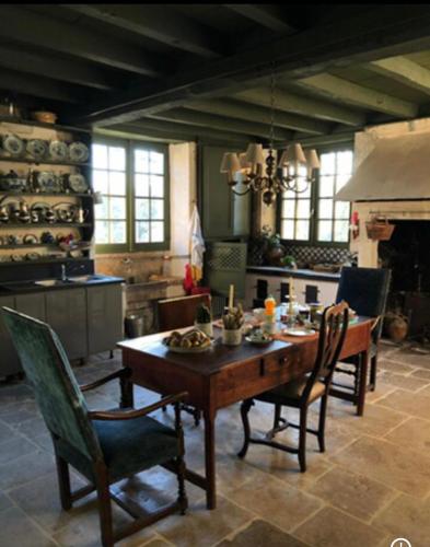 a dining room with a table and chairs and a fireplace at Chambres d'Hôtes Le Clos de Bonneval in Saint-Jean-de-Thouars
