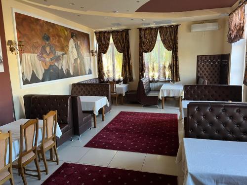 a restaurant with tables and chairs and a painting on the wall at Готель МАГНАТ in Sutysky