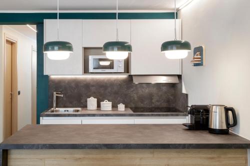 a kitchen with white cabinets and a counter top at HelloCHALET - Croix du Cervin - 150mt from Cretaz chairlift, central living in Breuil-Cervinia