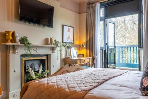 a bedroom with a bed and a fireplace and a television at The Crown Inn in Bromley