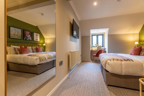 a bedroom with two beds and a mirror at The Crown Inn in Bromley
