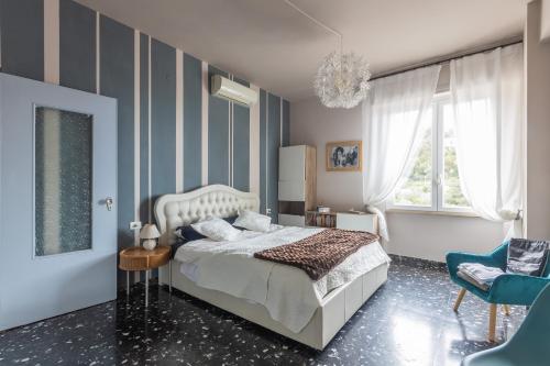 1 dormitorio con cama y pared de rayas azules en Sea view with terrace, La Casa Di Christine, en Monterosso al Mare