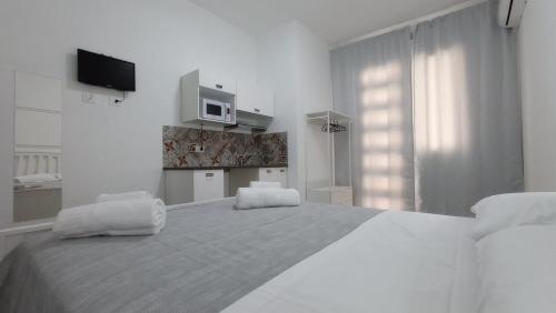 瑪爾薩梅米的住宿－Ciccina Rooms，白色卧室配有一张大床和两张白色椅子