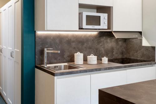 a kitchen with a sink and a microwave at HelloCHALET - Croix du Cervin - 150mt from Cretaz chairlift, central living in Breuil-Cervinia