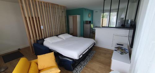 een kleine kamer met een bed en een bank bij Studio Zen in Niort