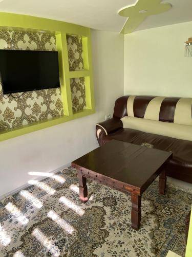 ein Wohnzimmer mit einem Sofa und einem Couchtisch in der Unterkunft Anisa- Hostel in Duschanbe