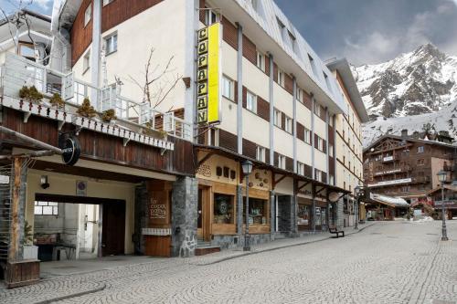 an empty street in front of a building with a mountain at HelloCHALET - Croix du Cervin - 150mt from Cretaz chairlift, central living in Breuil-Cervinia
