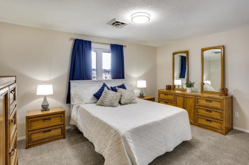 a bedroom with a bed with blue curtains and a mirror at Rapid City Apartment with Mountain Views! in Rapid City