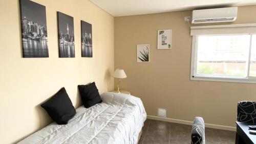 een slaapkamer met een wit bed met zwarte kussens erop bij BARCELONA APARTS in San Luis