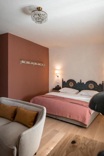 a bedroom with a bed and a couch at Leuchtenburg am See in Caldaro