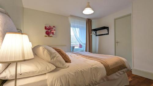 1 dormitorio con 1 cama con lámpara y ventana en Chambres d'Hotes CASCAROT en Lechâtelet