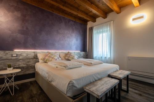 1 dormitorio con 1 cama grande y pared de madera en Atmosfere Charme & Country en Udine