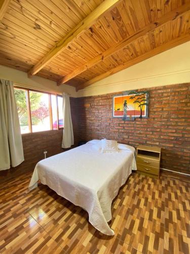 a bedroom with a large bed in a brick wall at Departamentos Fortin in Trevelin
