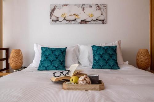 a bed with a book and glasses and a tray of books at Vicoletto by PortofinoHomes in Portofino