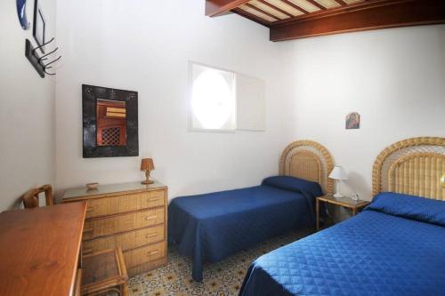 a bedroom with two beds and a dresser and a window at Antico Convento Sorrento in Sant'Agnello