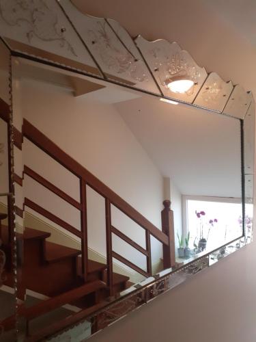 a mirror on a wall with a staircase in a room at Chambres d'Hotes CASCAROT in Lechâtelet